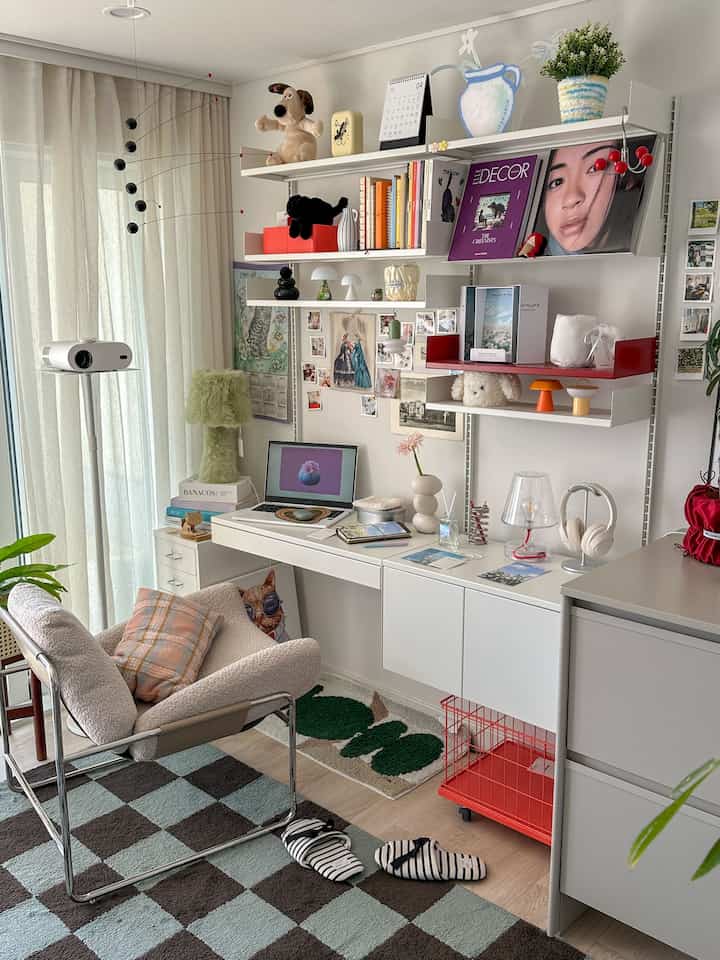 白とナチュラルカラーのホームオフィス、棚と机に本や雑貨が配置され、雰囲気のあるインテリア空間