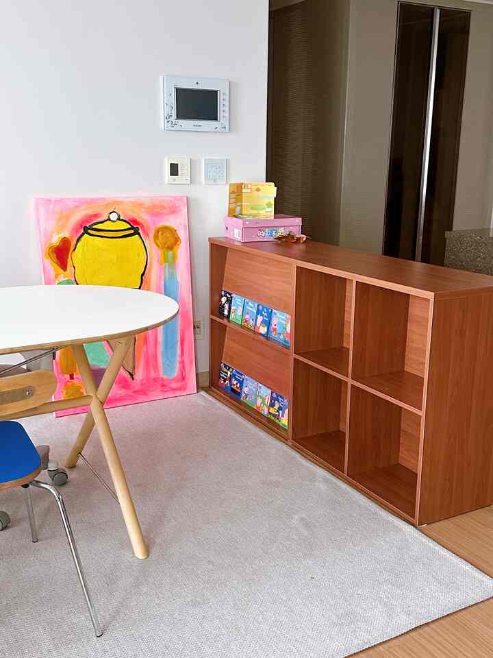 木目調家具と白いテーブルが配置されたリビングと子供部屋の空間、ミニマルで温かみのある雰囲気