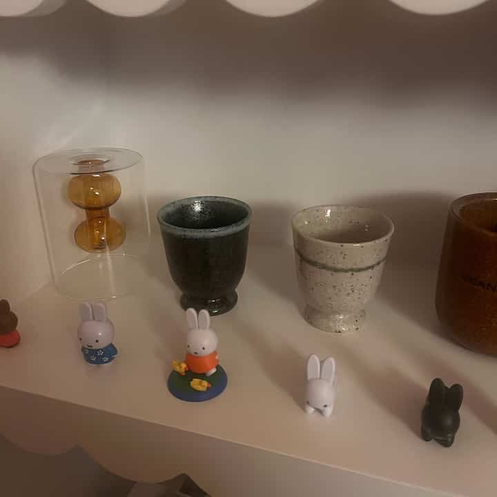 ナチュラルカラーとホワイトトーンの棚に、小さな器と可愛いウサギのオブジェが並ぶ雰囲気のあるインテリア