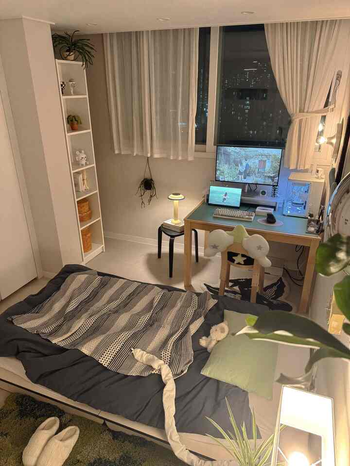 白と木目調が調和したワンルーム寝室、デスクと寝具が配置された雰囲気のあるミッドセンチュリーモダンインテリア