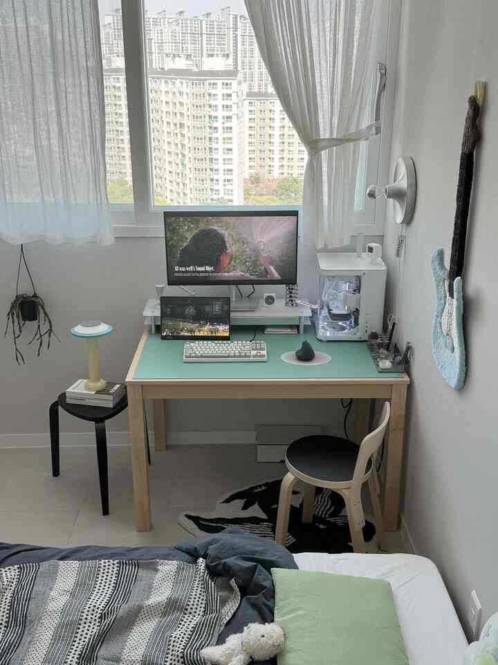 ホワイトトーンの寝室、ナチュラルモダンなデスクと椅子、パソコンモニターが配置された印象的なホームオフィス空間