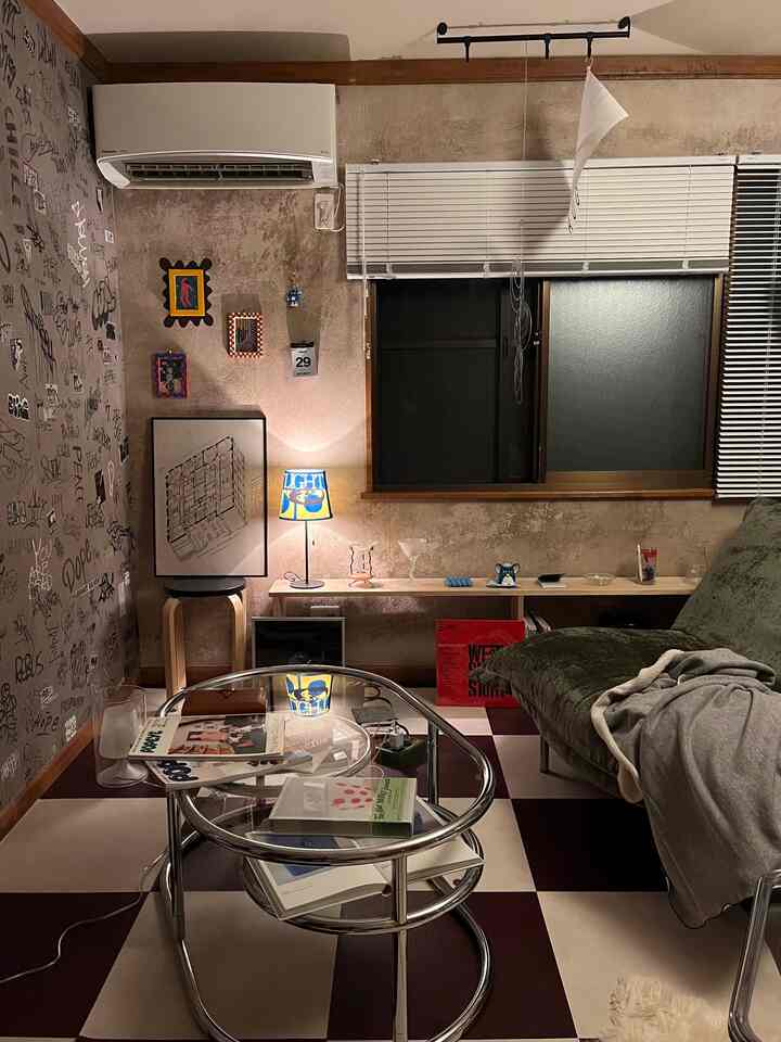 ベージュとブラウンの色調のリビング、ヴィンテージ壁紙とアートポスター、間接照明が配置されたナチュラルモダンな雰囲気のあるインテリア