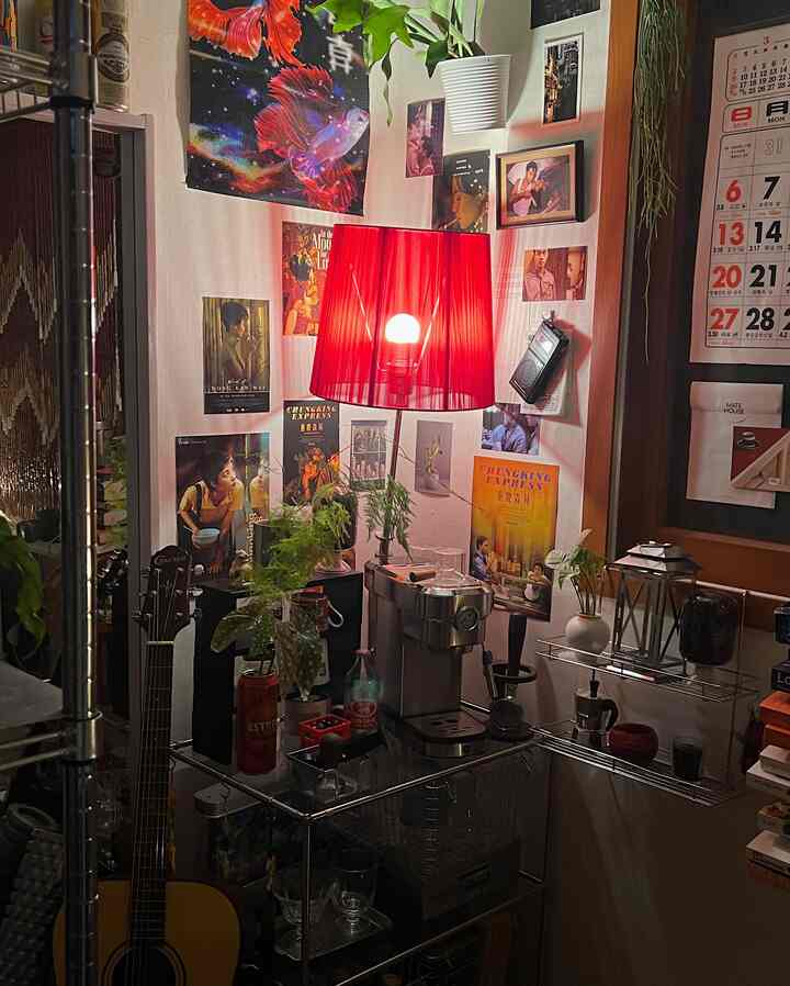 赤い壁照明が印象的な狭い一人暮らしのおうちカフェ空間、コーヒーマシンとポスターが壁に配置された温かみのあるインテリア