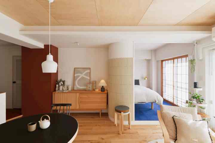 ナチュラルな木目調とブルーのカーペットが調和した二人暮らし向けのリビングとつながる寝室の空間