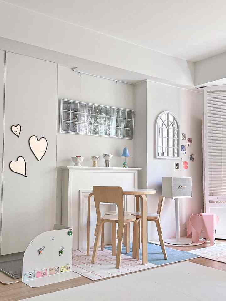 明るいホワイトとナチュラルウッドトーンのリビング、丸いダイニングテーブルと子供用おもちゃが配された温かみのあるインテリア