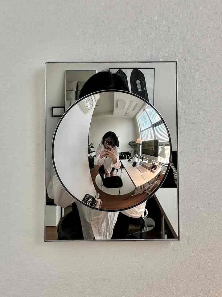 ホワイトとブラックのモノトーンのワンルーム、整理されたデスクと照明が配置されたシンプルモダンなインテリア