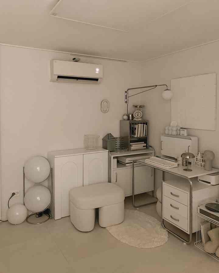 ホワイトとナチュラルトーンの書斎、書棚やキャビネット、スツールが配置された雰囲気のあるモダンなインテリア