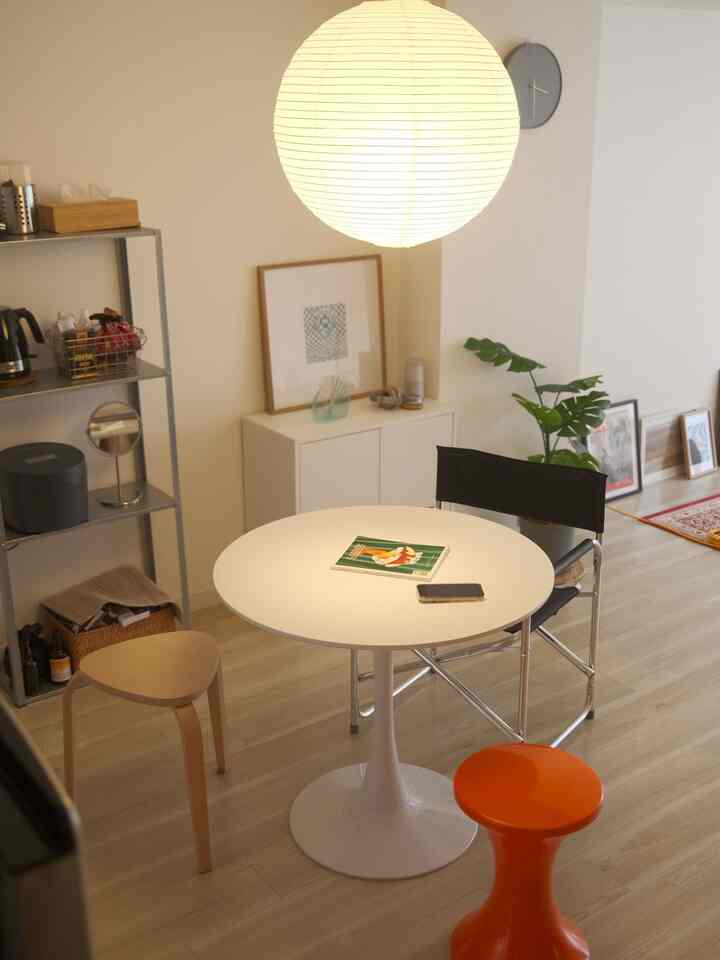 Natural color and white-toned dining space featuring various stools and indirect lighting in a Mid-Century Modern style interior