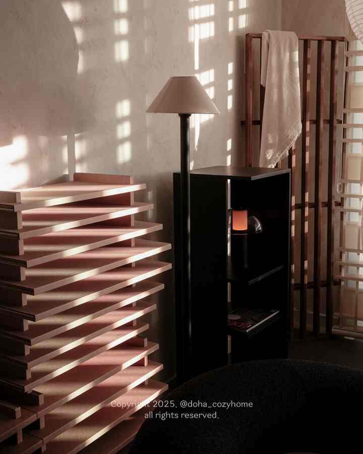 Natural color and black tones harmonize in a tidy storage corner with warm sunlight and natural material accents