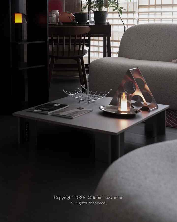 A soft mid-tone living room featuring a low coffee table and candle creating a cozy atmosphere