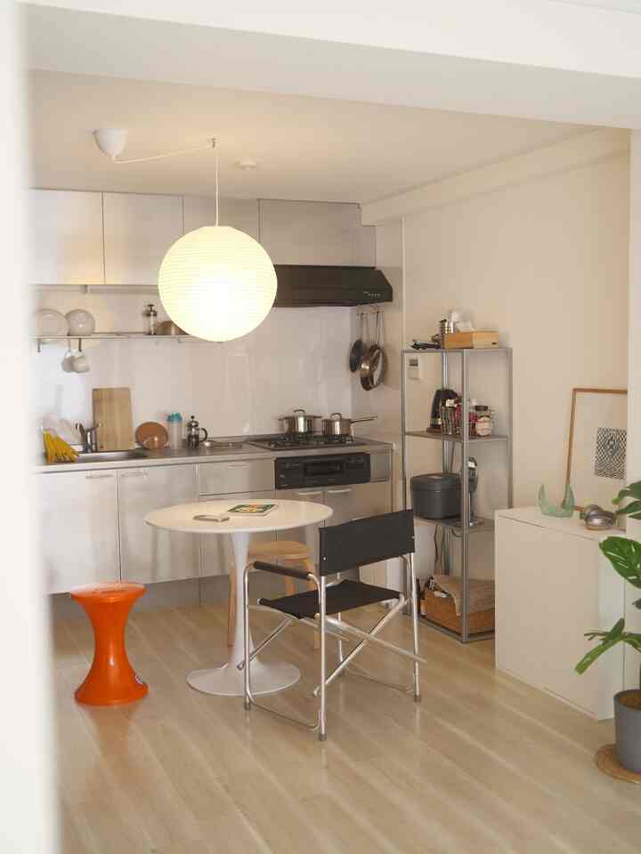 White and wood toned kitchen featuring minimalist dining table and chairs with a cozy, simple atmosphere