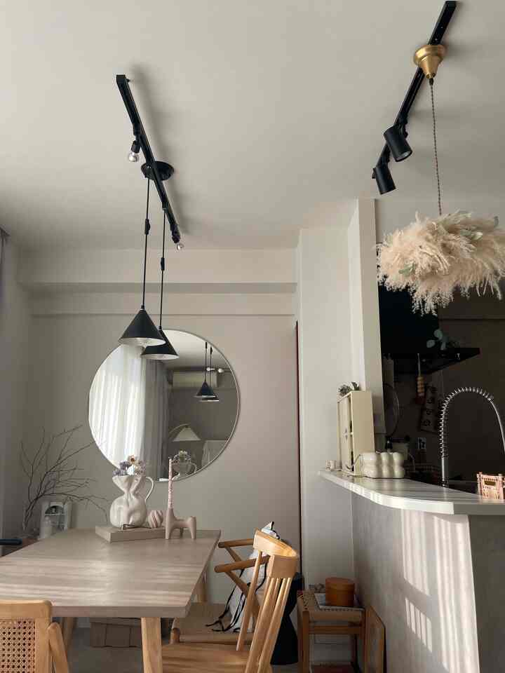 白い壁とナチュラルウッド調のダイニングテーブルが配置されたモダンな4人用ダイニングスペース