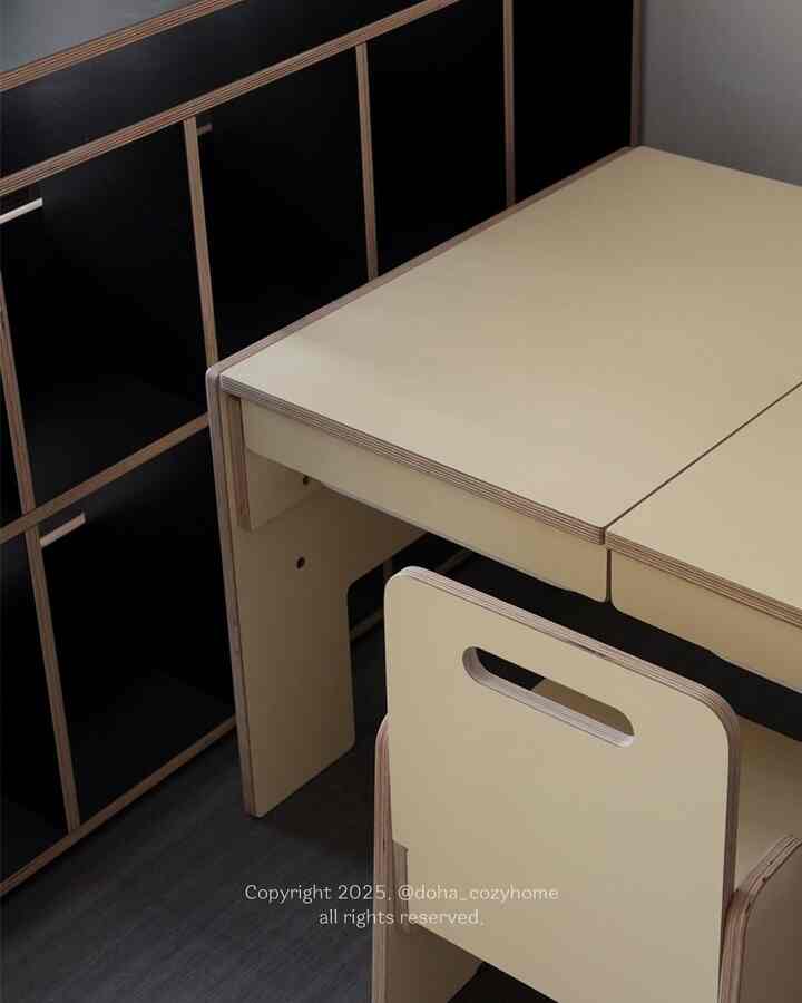 Beige desk and chair with black cabinet, arranged in a simple and open-feeling workspace