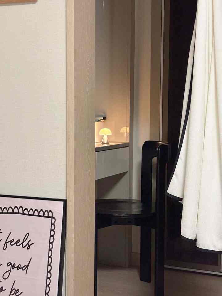 Natural color toned bedroom vanity space featuring a black wooden chair with modern and sleek atmosphere