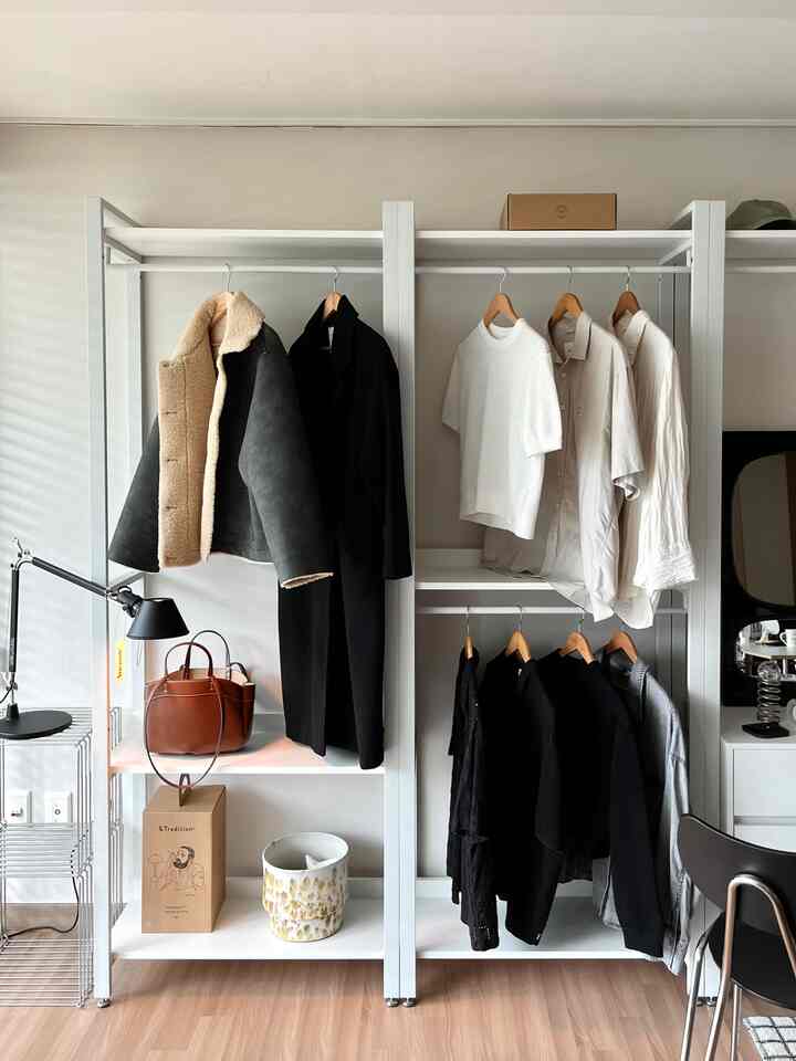 白と茶色のトーンの玄関スペース、シンプルなワードローブに整理された衣服が配置された雰囲気のあるインテリア