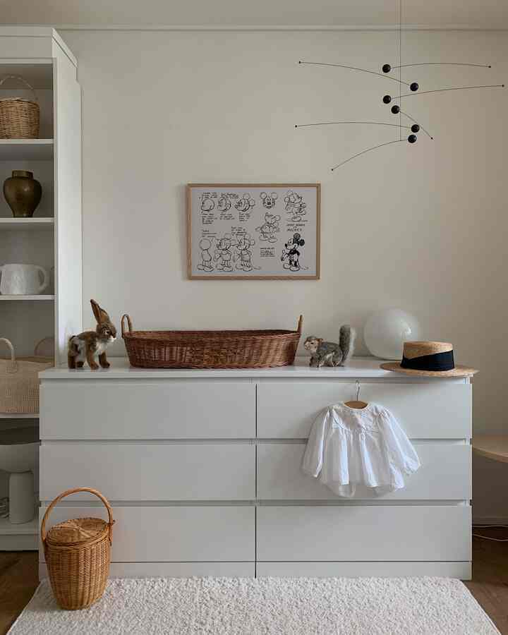 白と木目調の子供部屋、ミッキーの額縁とチェストが配置されたナチュラルで雰囲気のあるインテリア