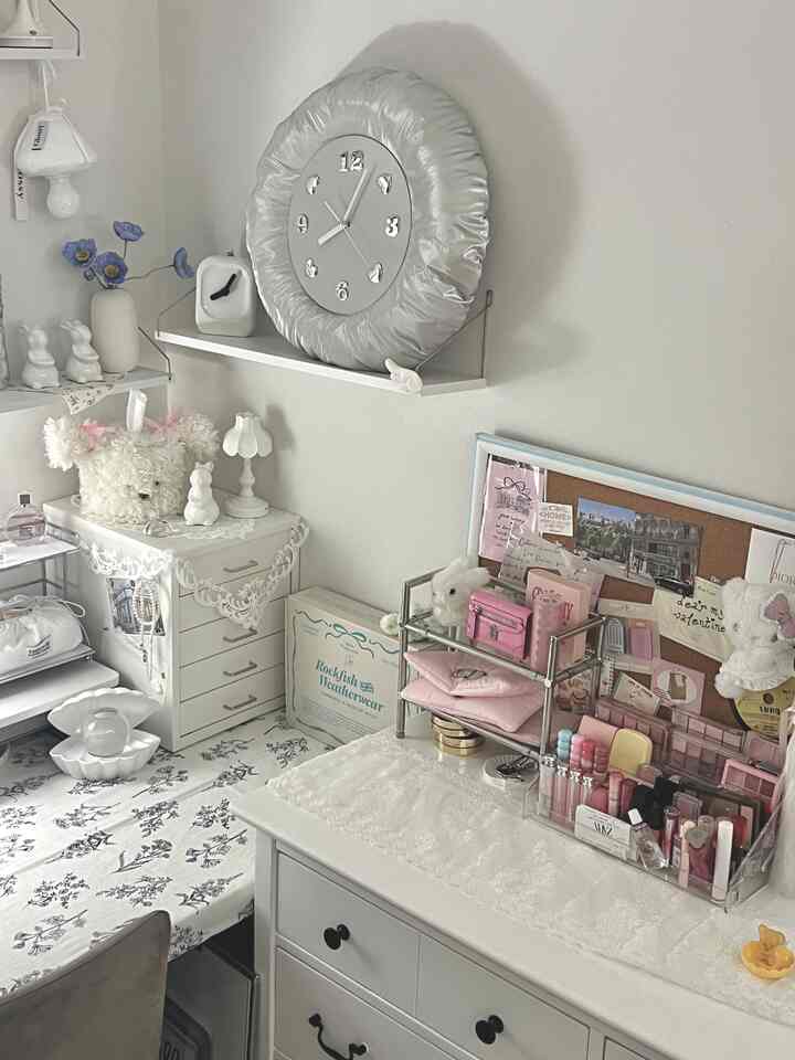 白とピンクのトーンの化粧台空間、アクリルの化粧品収納とヴィンテージ感のある小物が調和した雰囲気のあるインテリア