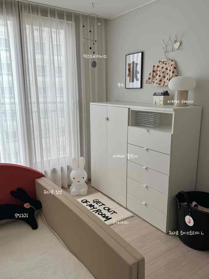 白とナチュラルな色調の赤ちゃん部屋、イケアのワードローブとベージュのベビーベッドが配置された落ち着いた雰囲気のインテリア