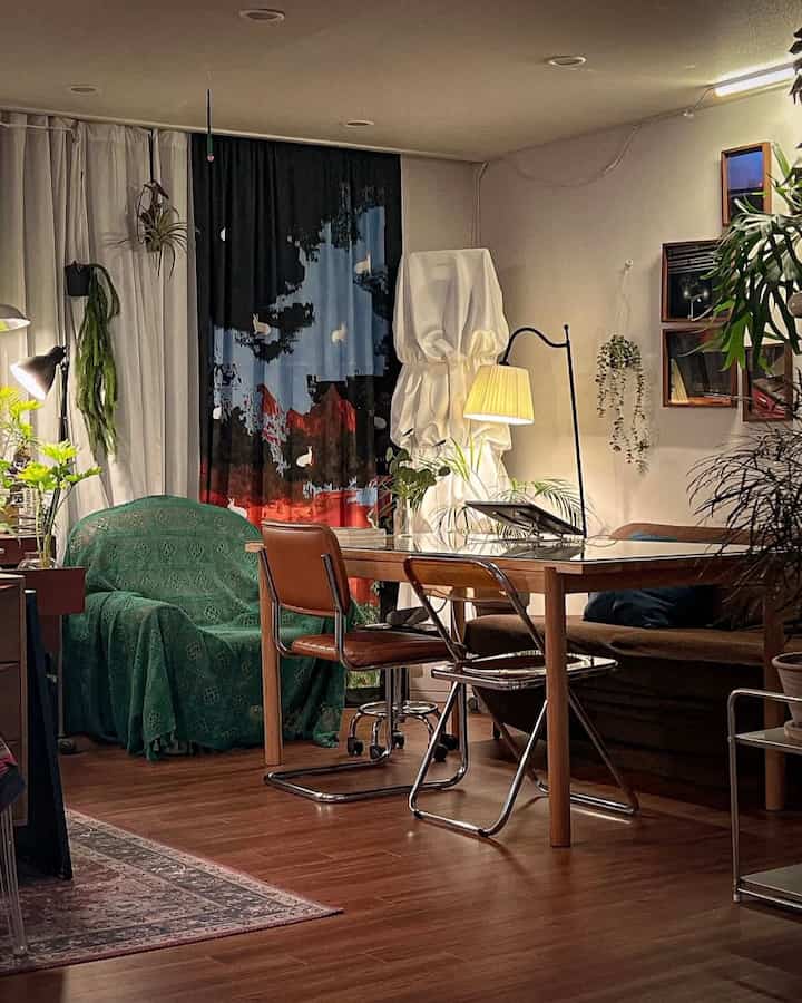 Natural wood tone and green plants blend in a vintage style living room featuring dining table, sofa, and floor lamp in a cozy setting