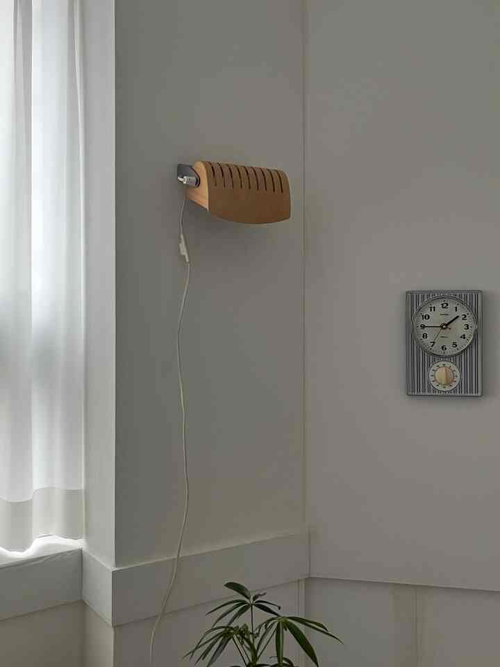 Natural style bedroom with white walls and wood-tone wall lamp