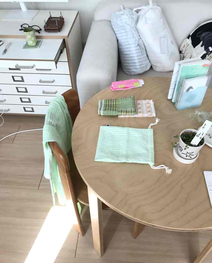 明るいナチュラルトーンのリビングとダイニングスペース、白いソファと丸い木製のダイニングテーブルが配置された居心地の良いインテリア