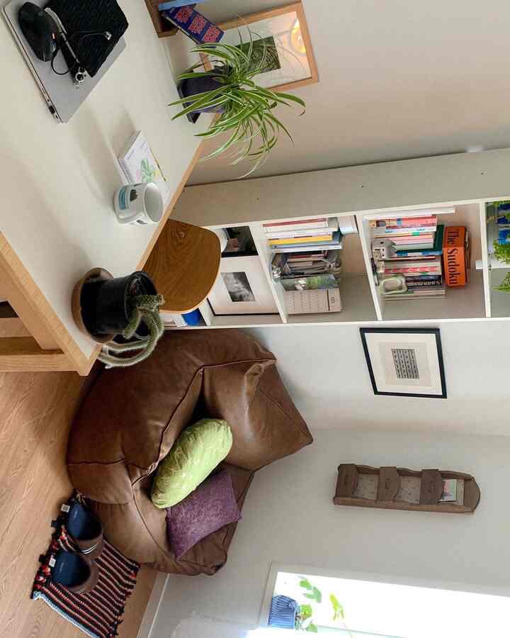 ナチュラルな木目調の色合いが特徴の狭い部屋、茶色のビーズクッション、本棚、テーブルが配置された落ち着いた空間