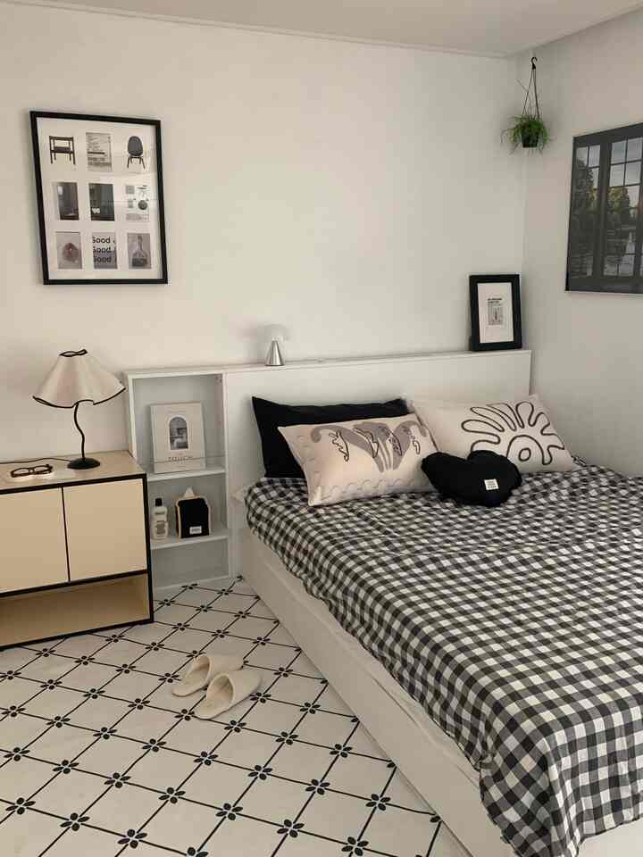 White and black toned bedroom featuring a bed frame with storage and clean minimalist interior design