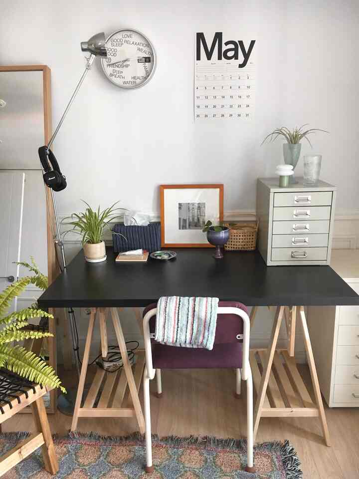 白い壁と黒いデスクが調和したモダンなホームオフィス、木目調家具と植物が配置された整った作業空間