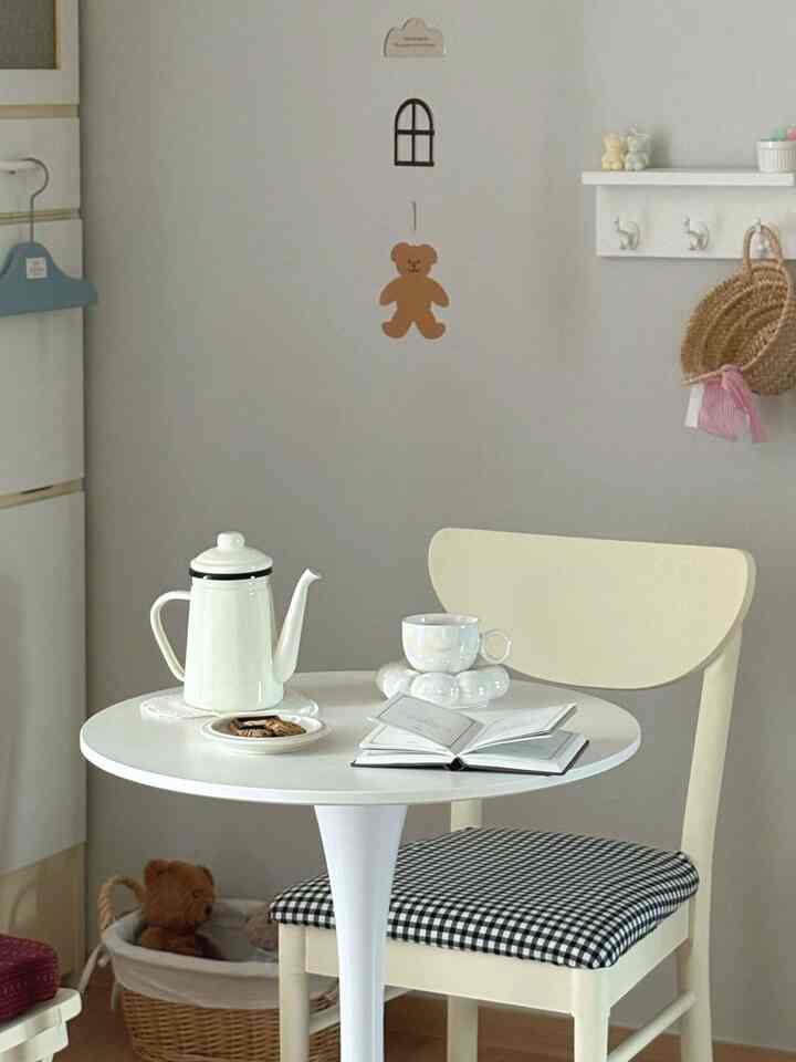 明るいクリーム色の椅子と白い丸テーブルが配置されたシンプルで居心地の良いおうちカフェ空間