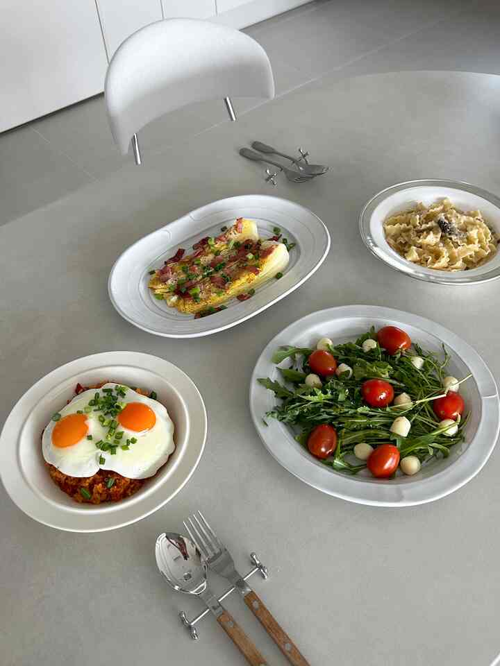White and gray toned dining room featuring a simple dining table and plates in a neat setting