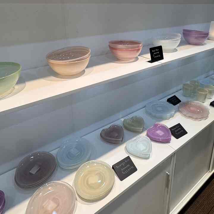 柔らかなパステルトーンの食器が、清潔感のあるナチュラルなキッチンスペースに整然と並べられている