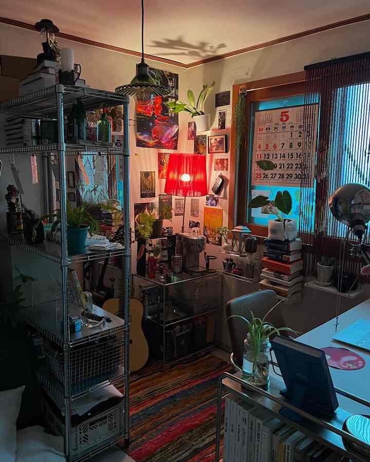 暖かい赤色の照明と多彩なインテリア、小物、植物、コーヒーマシンが配置された居心地の良い小さな部屋の雰囲気のあるインテリア