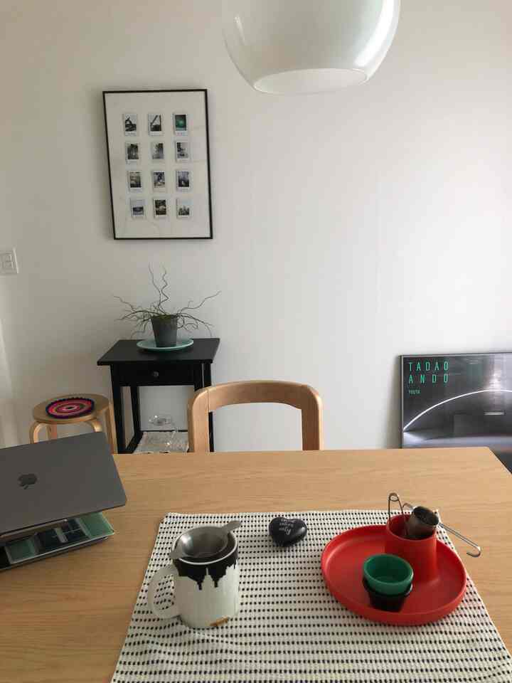 白い壁と天井のナチュラルな2人用ダイニングスペース、木製のテーブルとチェア、ホームカフェ用のコーヒー用品が配置されたシンプルモダンなインテリア