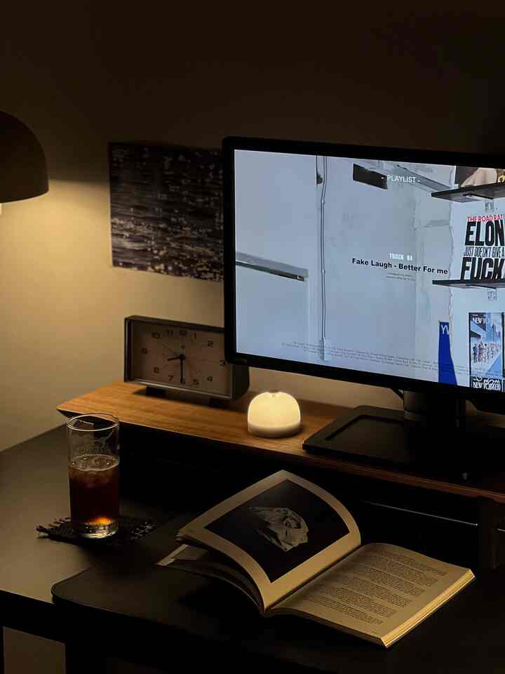 ブラウンとブラックのモダンな寝室のデスク空間、モニターとランプが配置された落ち着いた読書に適したインテリア