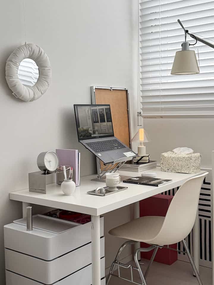 White tone home office space featuring a stainless steel organizer on a simple desk and chair with modern interior design