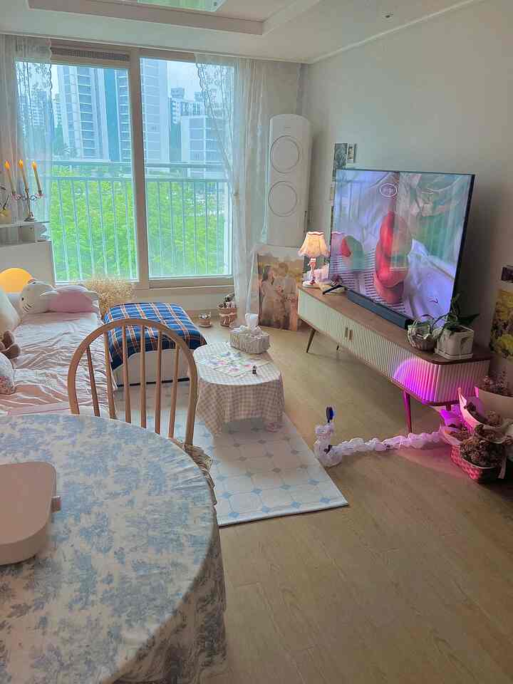 白を基調としたリビング、ヴィンテージスタイルのレースカーテンやフロアランプ、壁コンソールが配置された雰囲気のある空間