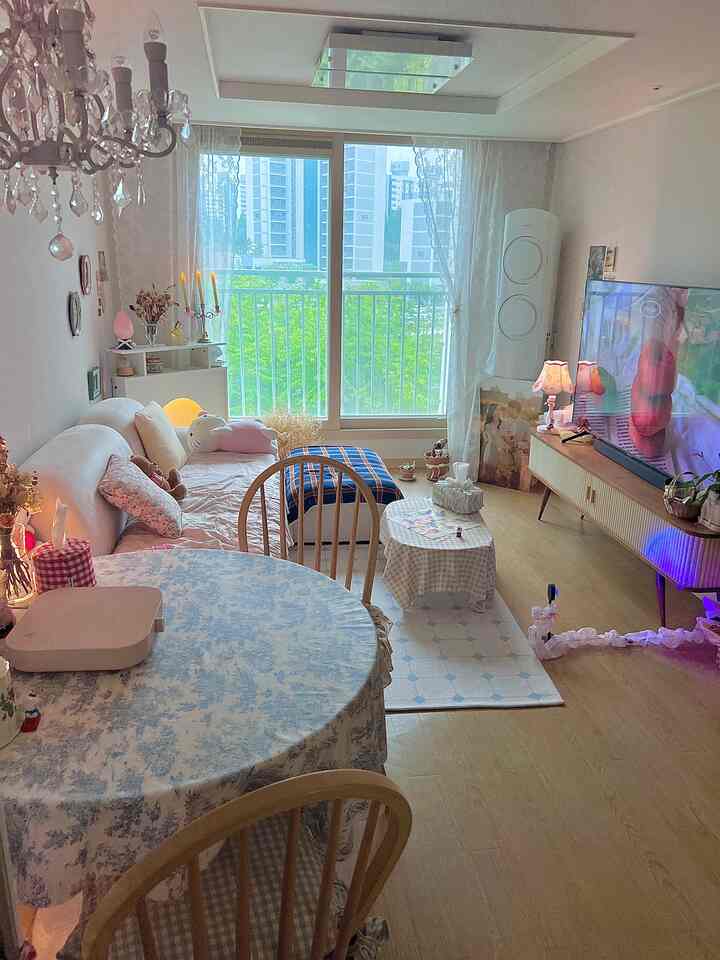 明るいホワイトトーンとナチュラルウッドが調和したリビング、シャンデリアとカーテンが印象的な雰囲気あるおうちカフェ空間