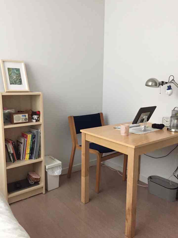 白い壁とナチュラルな木製家具が配置されたシンプルな一人暮らし用ホームオフィス空間