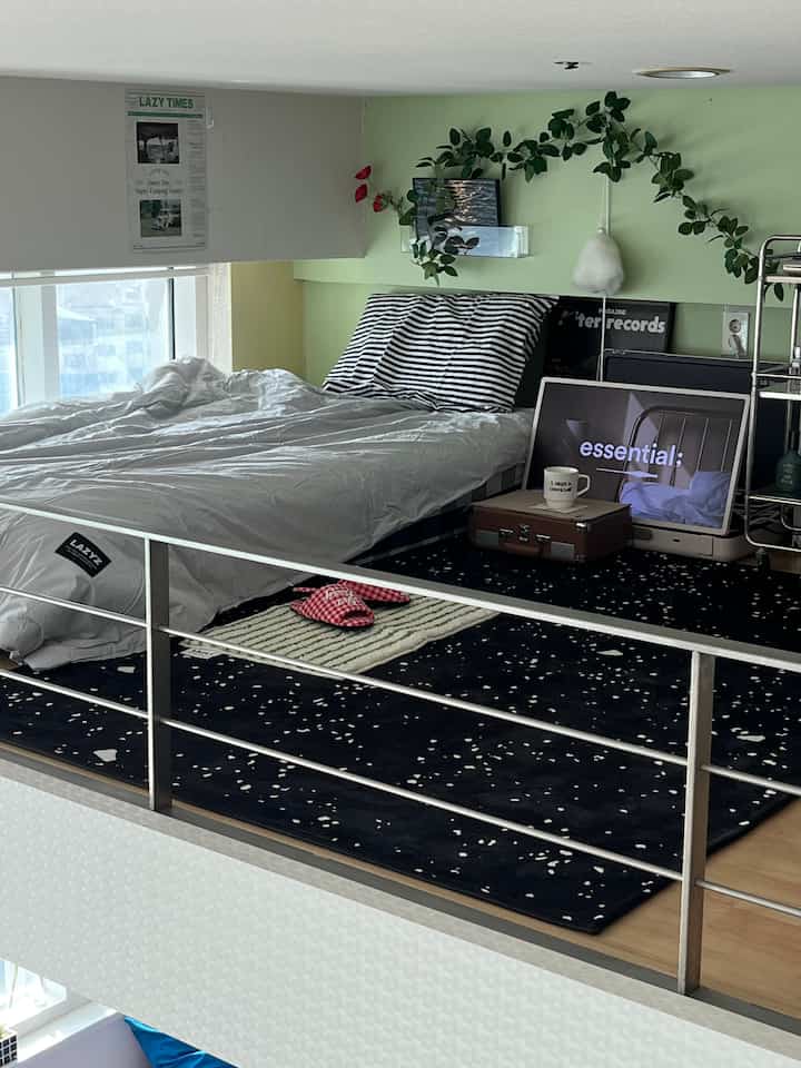 White and navy toned loft bedroom featuring starry rug and striped pillows in a modern cozy setting