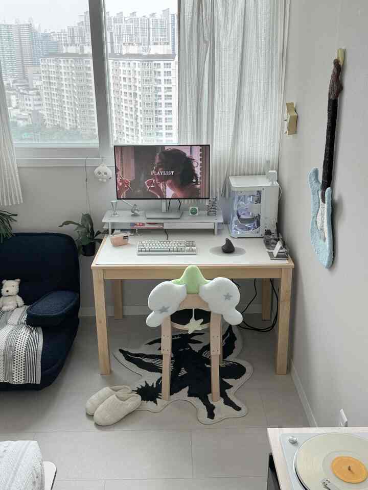 ナチュラルウッドトーンとモノトーンが際立つ一人暮らし向けのホームオフィス空間、すっきりとしたデスクとモニター設置が特徴