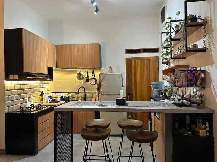 Warm wood tone kitchen featuring black accents, wooden stools, and organized shelving creating a cozy atmosphere