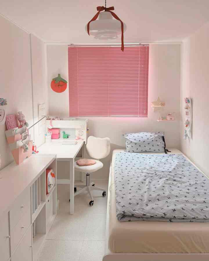 ピンク色のブラインドが映える白い子供部屋、机とベッドがすっきり配置された落ち着いた雰囲気のインテリア