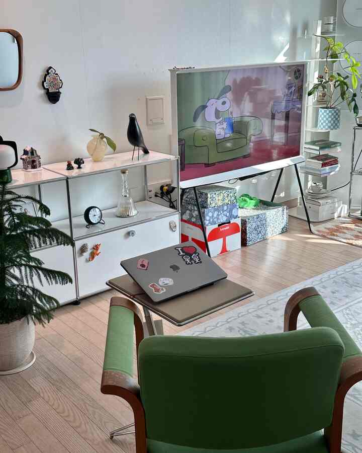 ホワイトとグリーンの色調のリビング、テレビスタンドとモニタースタンドが配置されたシンプルでナチュラルな雰囲気のインテリア