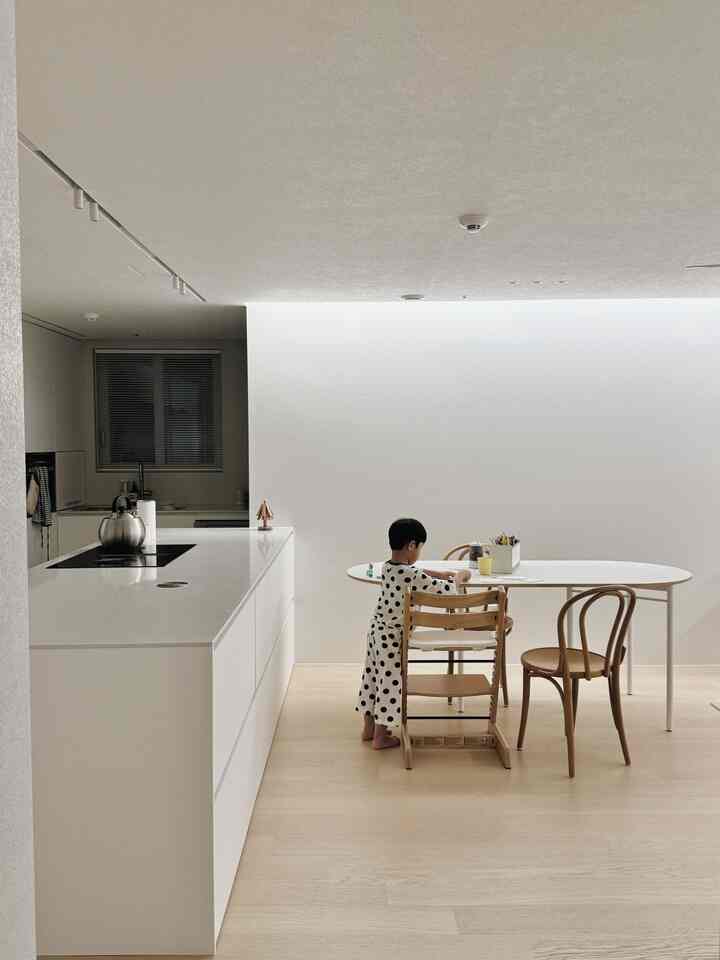 白とナチュラルな色調のキッチンとダイニングスペース、子供がいるミニマルな雰囲気のインテリア