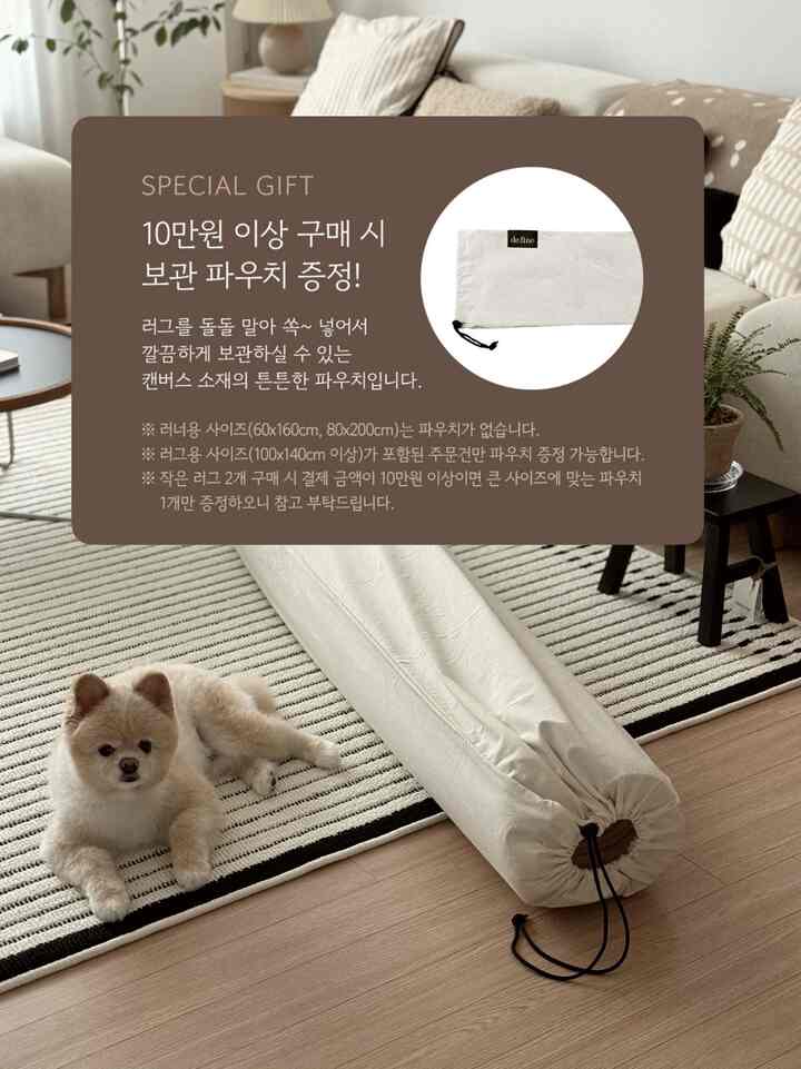 ナチュラルなウッドトーンの床にベージュのソファが配置され、黒と白のストライプのラグの上に犬が横たわる、雰囲気のあるリビング