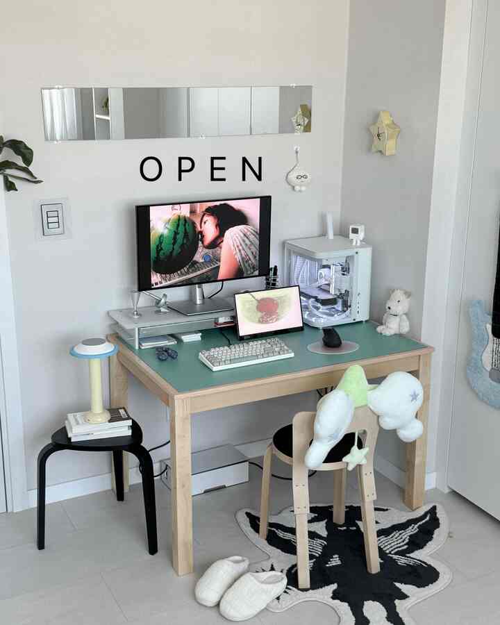 白と木目調の調和したホームオフィスのデスク、グリーンのテーブルマットとモニター、スツールが配置されたシンプルな雰囲気のインテリア