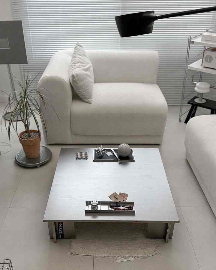 シルバーのトーンが特徴的なリビング、モダンでシンプルなインテリアに白いソファと四角いソファテーブルが配置された空間