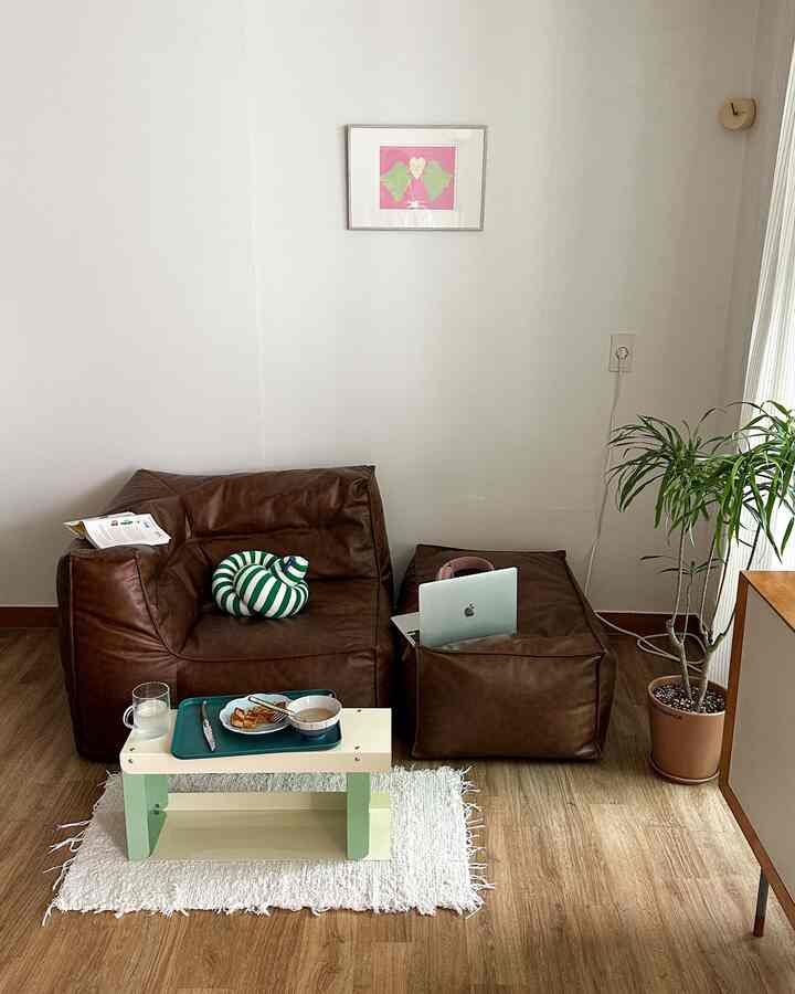 ナチュラルな木目調の床とブラウンのビーズクッションが配置されたシンプルで温かみのあるリビングスペース