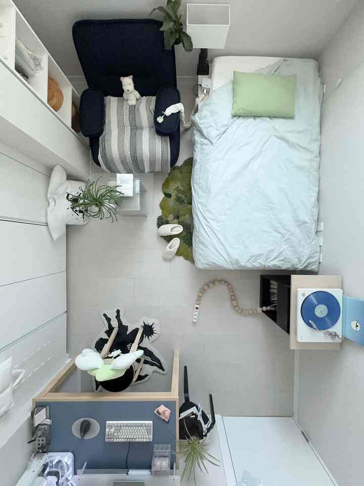 白と青のトーンのワンルーム寝室、シングルベッドと一人掛けソファが配置されたミニマルな空間