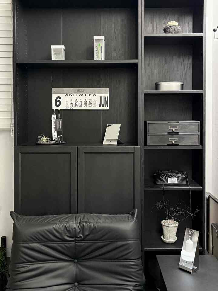 黒とモノトーンのホームオフィス空間、黒いレザーの椅子と棚、シルバーのミニスタンドミラーが配置されたシンプルでモダンなインテリア